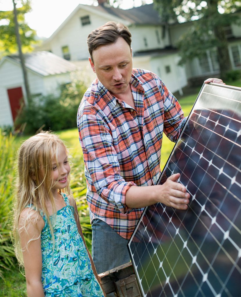 A Man Showing a Solar Panel to His Daughter